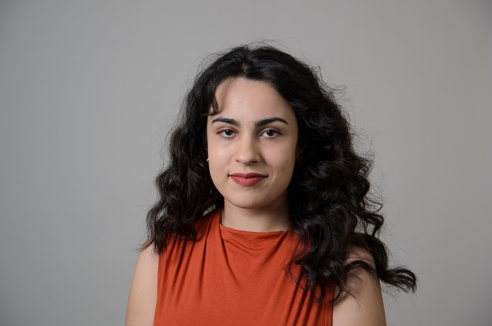 Portrait of Liliana Oliveira wearing an orange shirt.