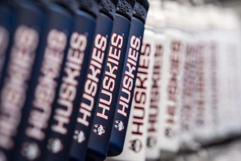 Navy and white water bottles with the word Huskies running down the side of each.